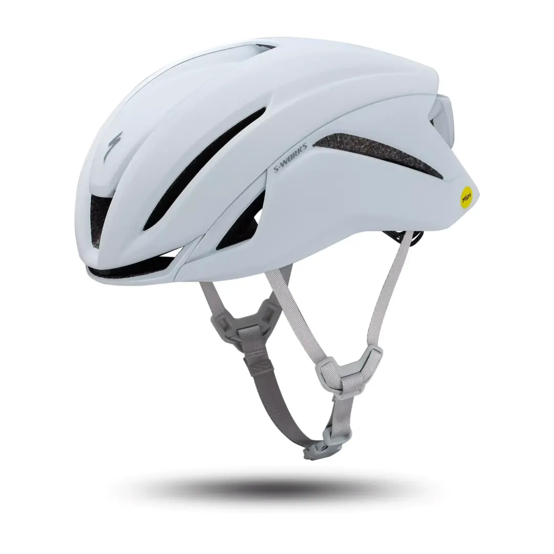 White bicycle helmet with multiple vents and gray chin straps, viewed from the side with a yellow MIPS sticker visible on the back