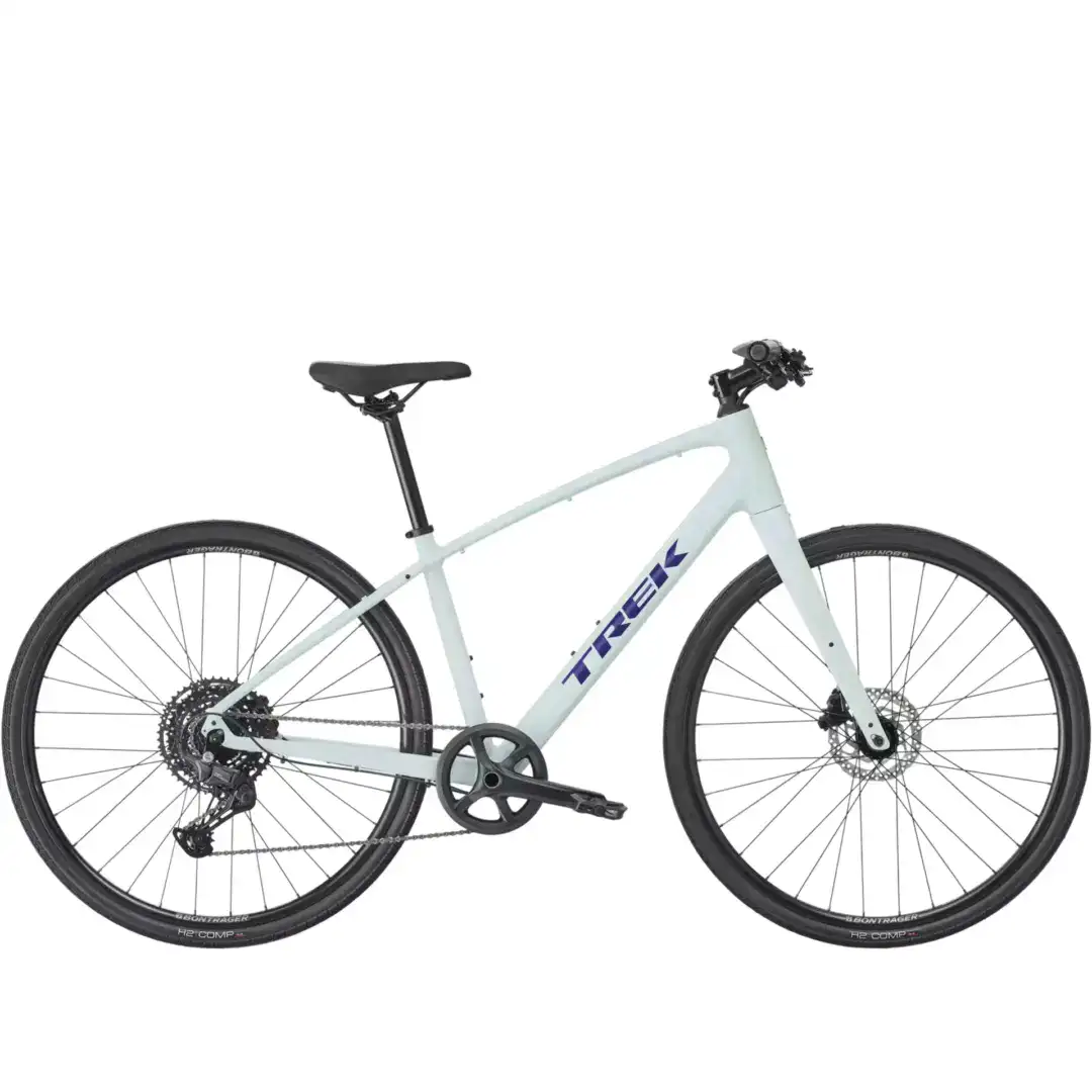 Side view of a light blue Trek bicycle showing the saddle, frame, handlebars, and two wheels with gears and disc brakes