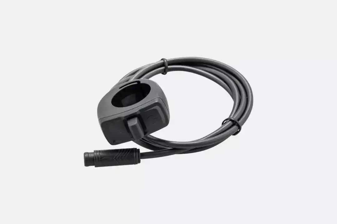 Coiled black power cable with a round, recessed connector housing at the end, shown against a light background.