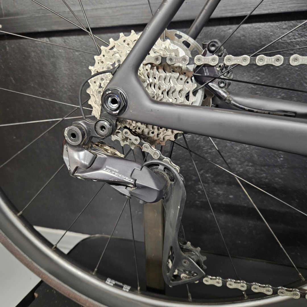 Close-up of a bicycle's rear derailleur and cassette with the chain on the gears.