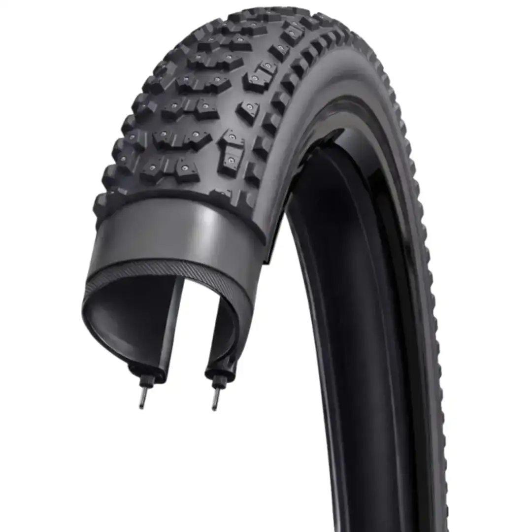 Close-up of a studded off-road bike tire with knobby tread on a rim.
