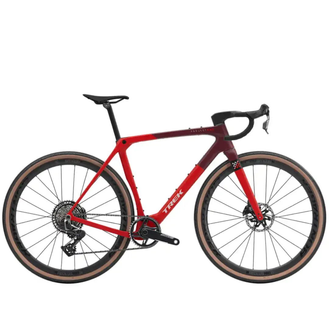 Red Trek road bike shown from the side with drop handlebars and large wheels against a white background, frame in red.