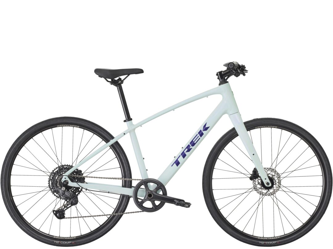 Side view of a light blue Trek bicycle, showing the saddle, frame, and two wheels, cropped mid-section.