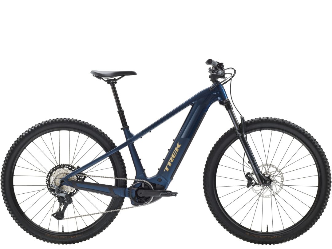 Blue full-suspension mountain bike shown from a side view with visible front and rear wheels and drivetrain components (chain, gears).