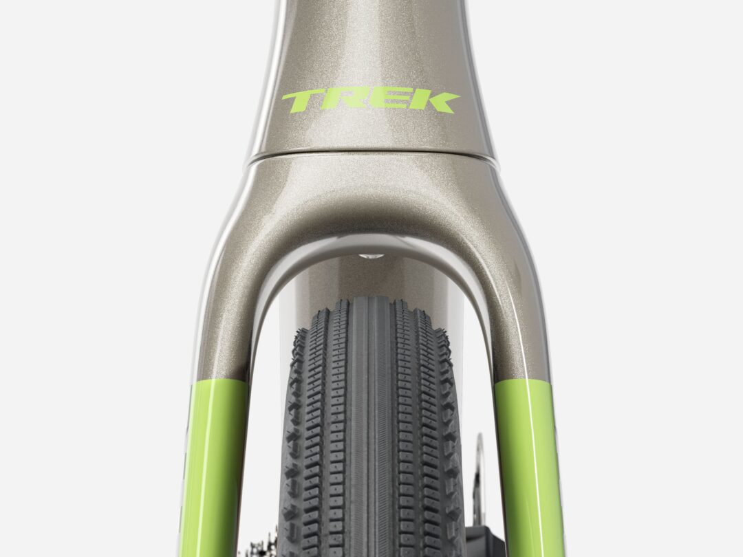 Close-up of a Trek bicycle's front fork and tire, silver frame with lime-green fork legs and knobby tire.
