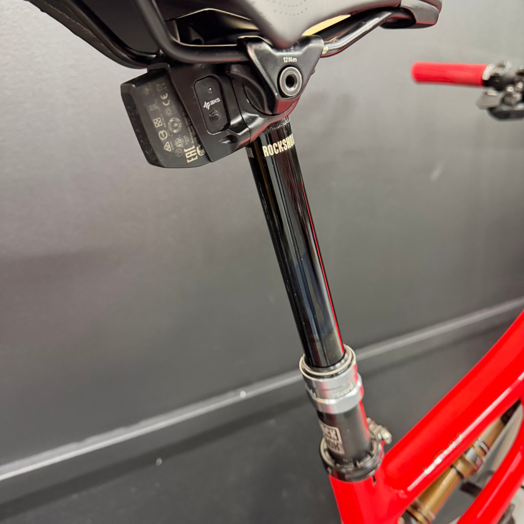 Close-up of a red mountain bike front suspension fork with RockShox branding.