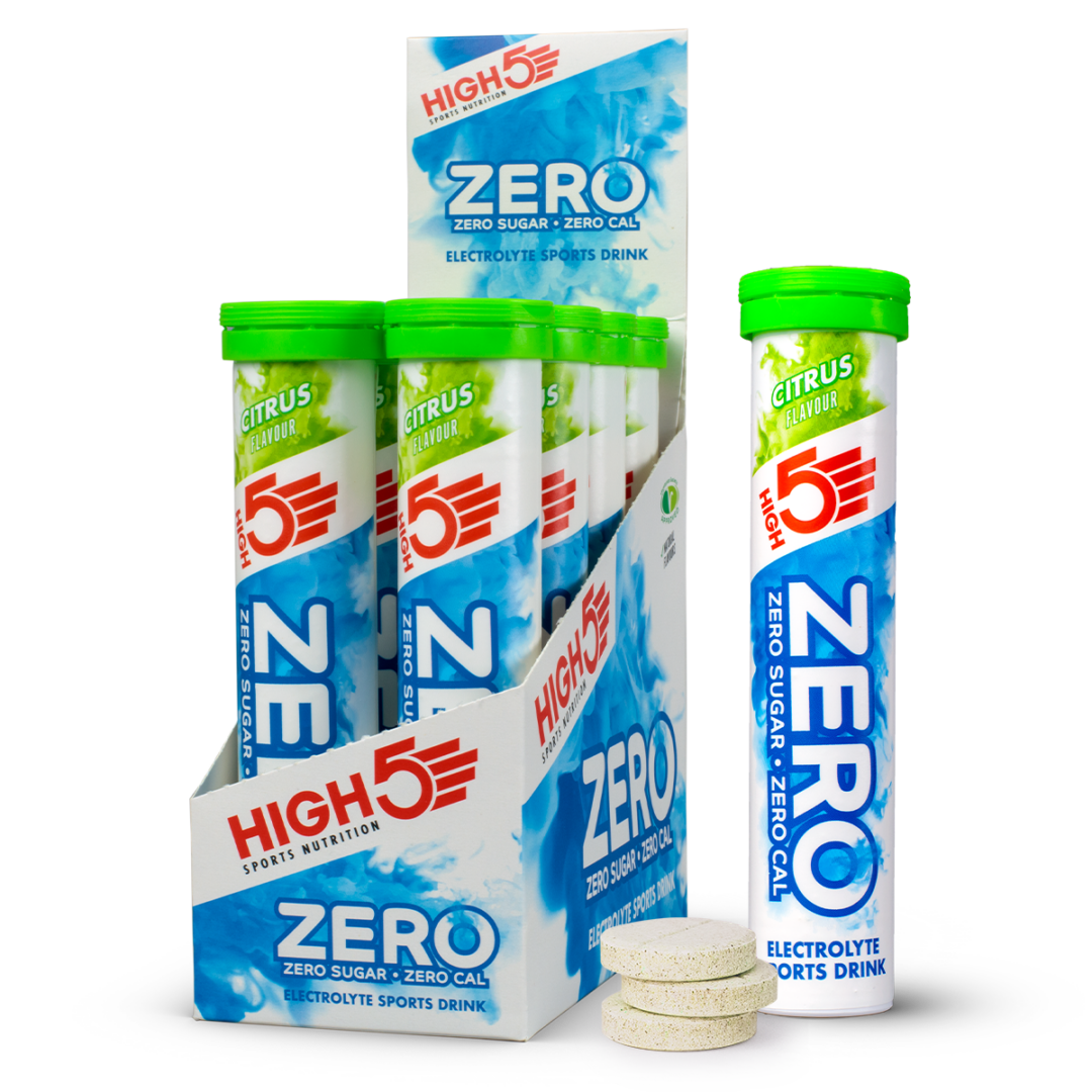 Assorted High5 Zero electrolyte drink sticks in a blue-and-white display box with lime-green caps and citrus-flavored tubes; three tablets nearby.