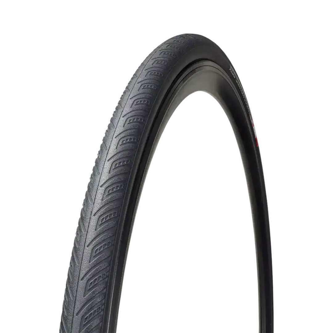 Close-up of a gray bicycle tire with patterned treads mounted on a curved wheel against a black background, showing the tread design and sidewall details.