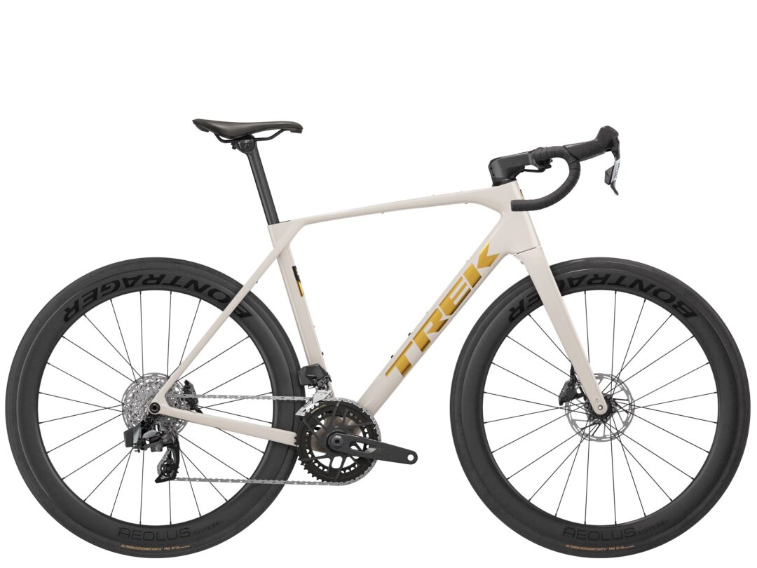 Side view of a cream-colored road bicycle with a black saddle, drop handlebars, and deep-section Aeolus wheels