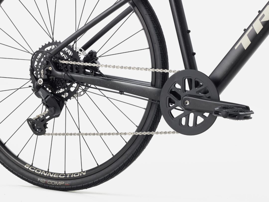 Close-up of a black bicycle drivetrain: rear derailleur, chain, cassette, and crank on a matte frame