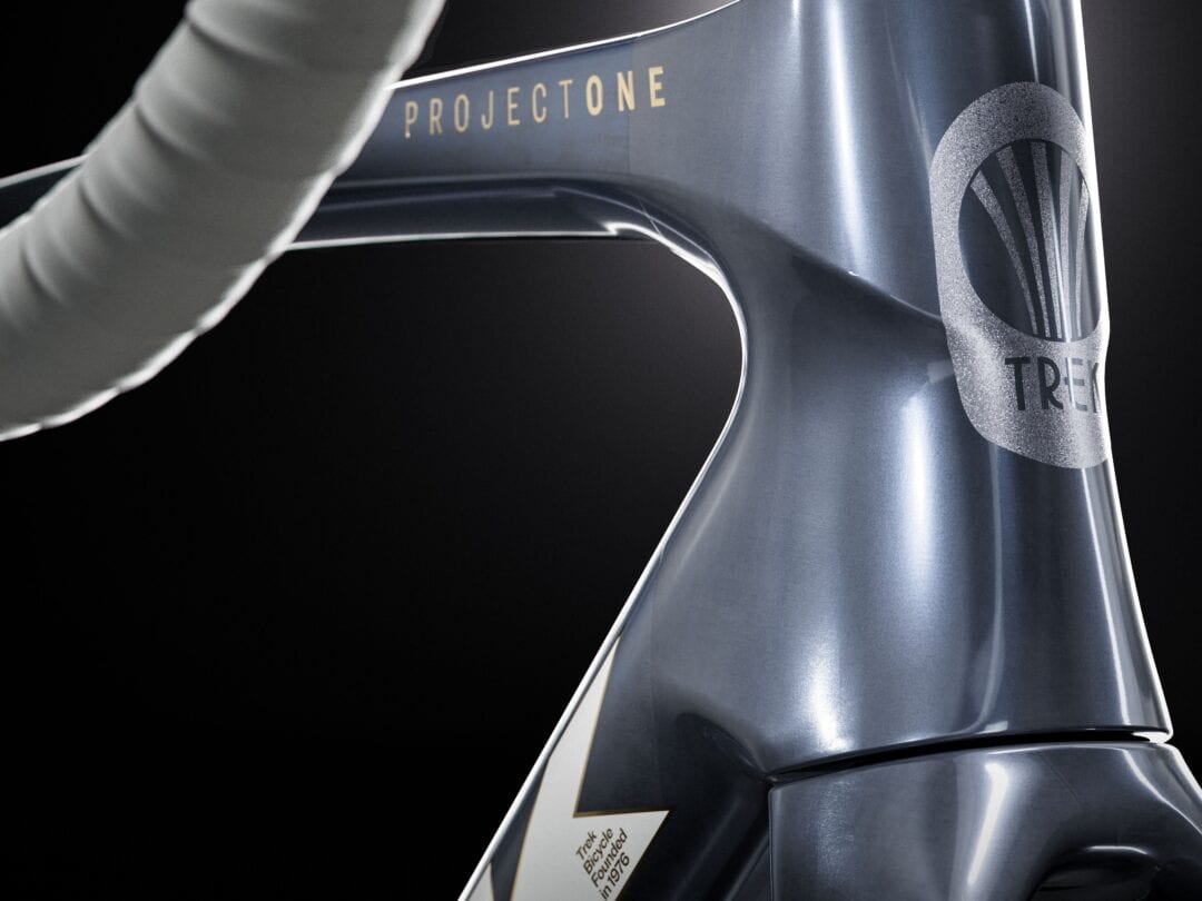 Close-up of a dark blue Trek bicycle frame with 'PROJECT ONE' on the top tube and a textured Trek logo visible on the right side.