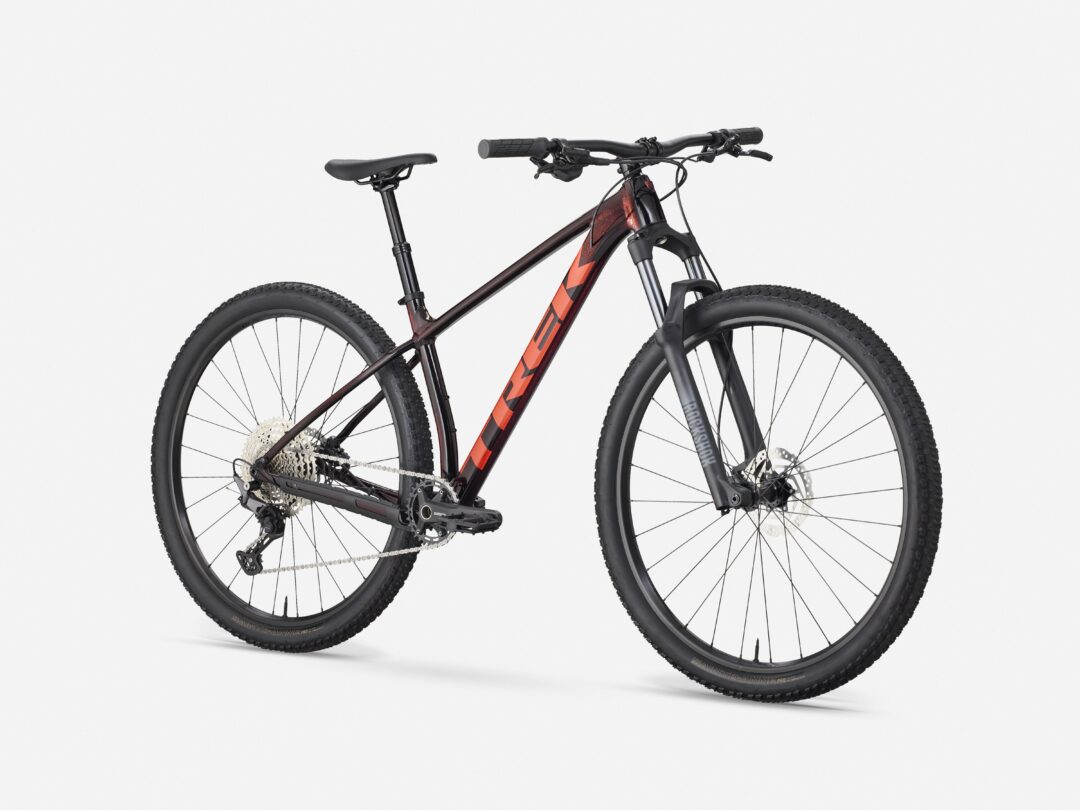 Black and orange mountain bike shown from the side, with thick tires and front suspension against a white background.