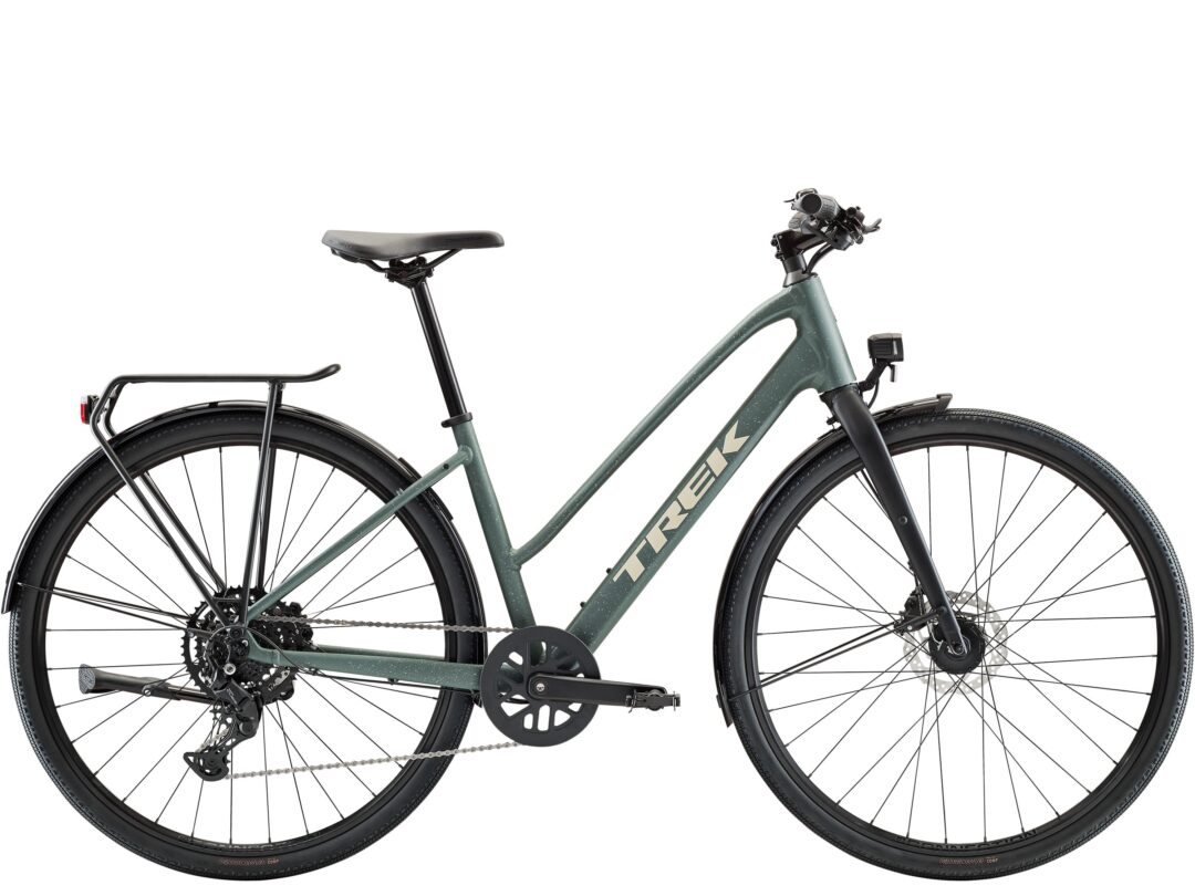 Green Trek bicycle frame between front and rear wheels, showing drivetrain, handlebars, and tires.
